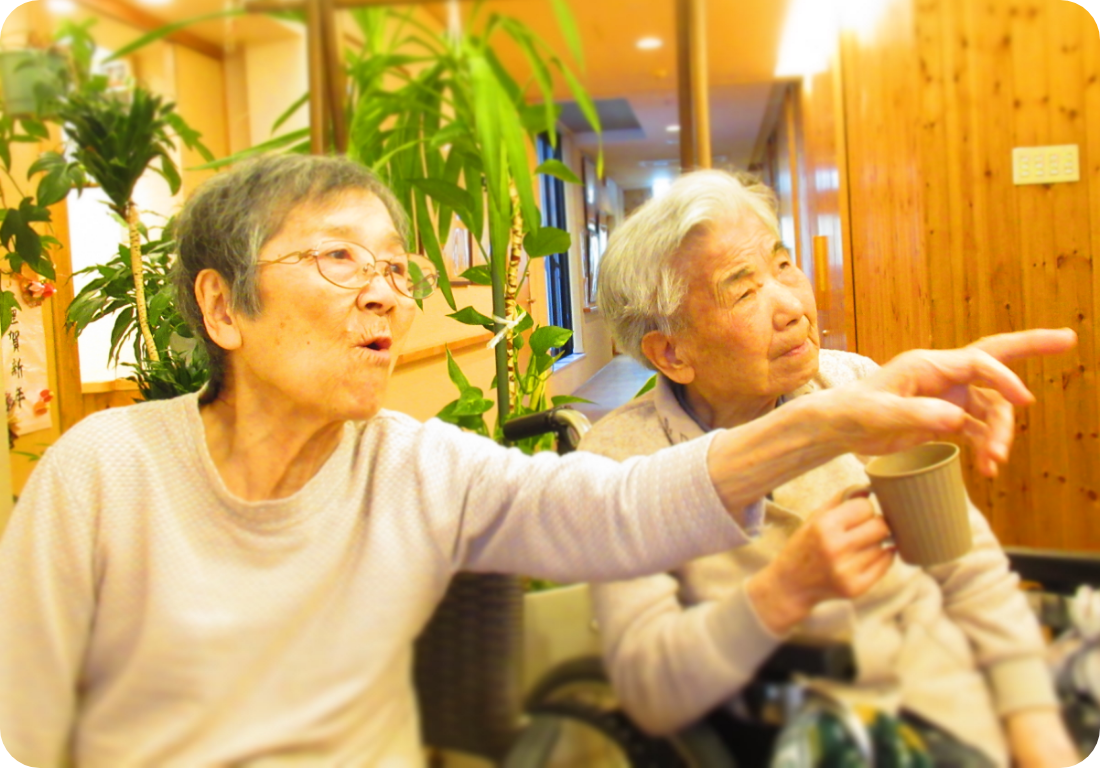 指をさす高齢の女性2人